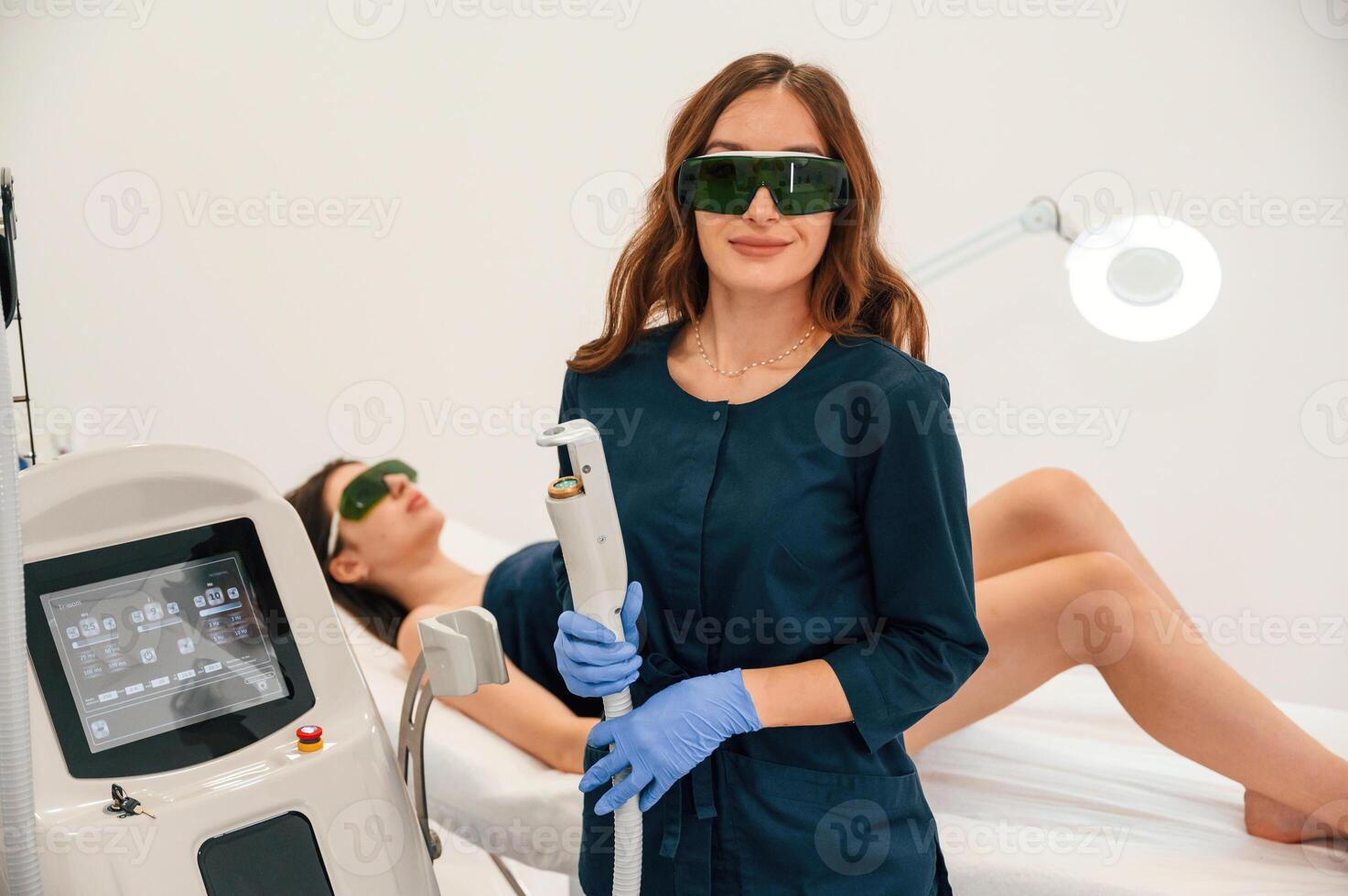 Holding ,device,. Getting photo rejuvenation procedure at cosmetology clinic. Women in beauty salon