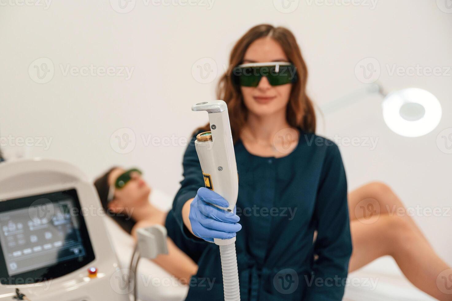 Holding device. Getting photo rejuvenation ,procedure at cosmetology clinic. Women in beauty salon