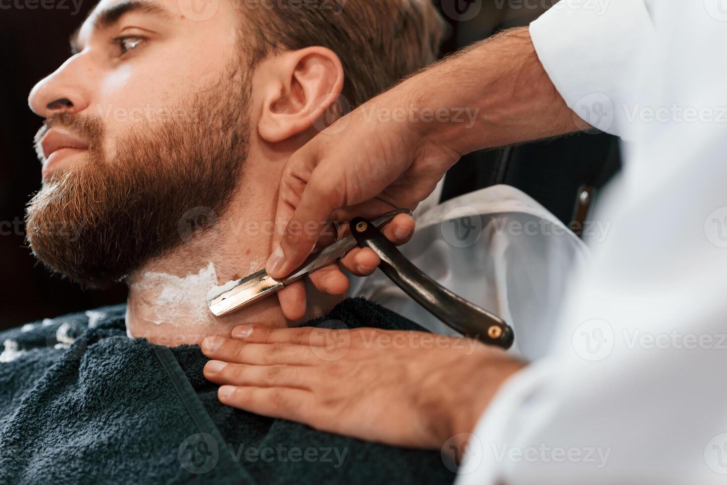Getting ,shaved. Man is visiting, modern barber shop. Modern style photo