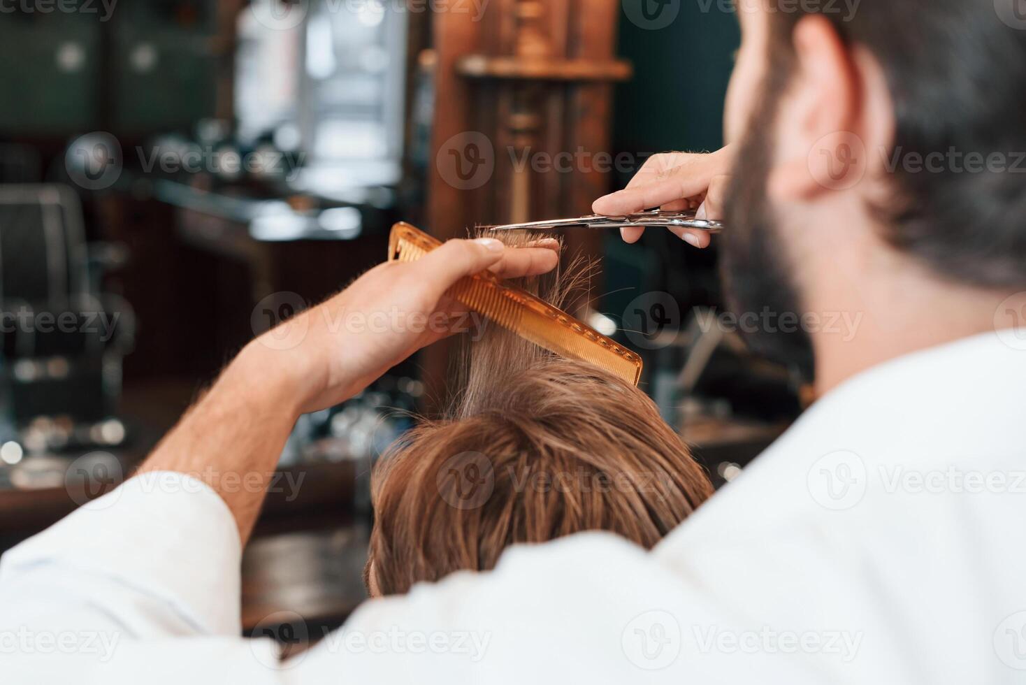 Rear view. Man is ,visiting modern barber shop. Modern style photo