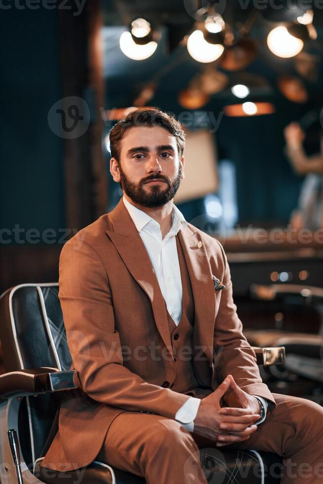 Handsome man, with beard is in the barber shop photo