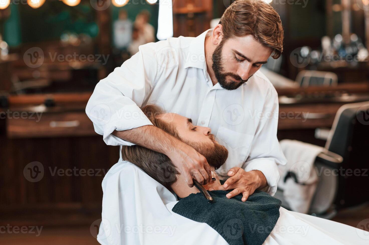 On the, neck, shaving the beard. Man is visiting modern barber shop. Modern style photo