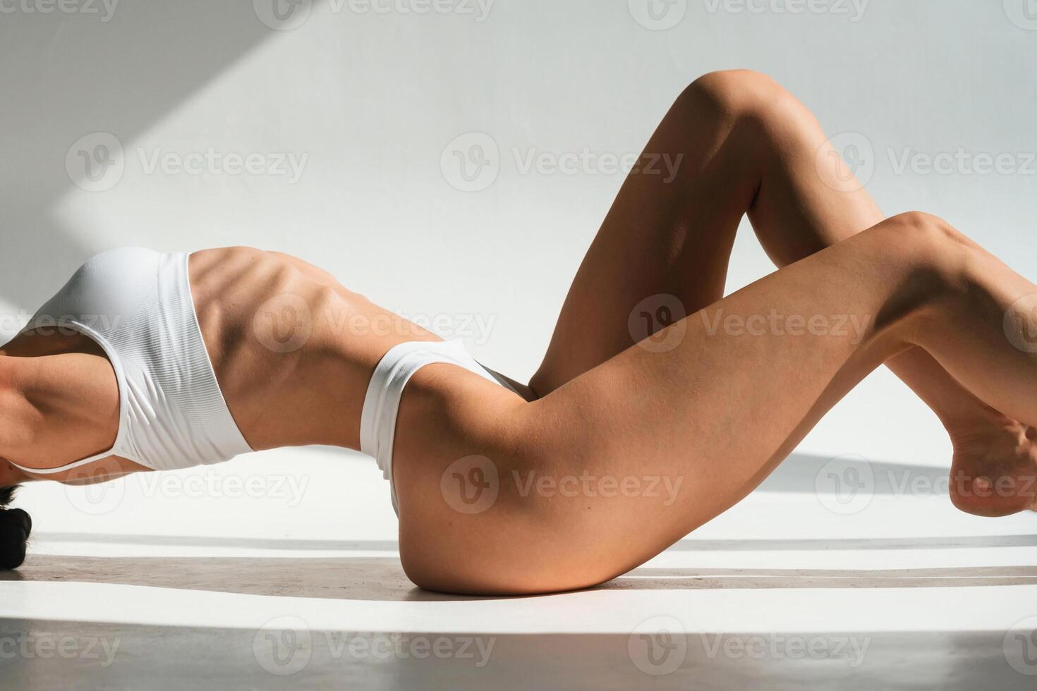 Daytime ,sunlight. Young woman with slim body type is in fitness clothes in the studio photo