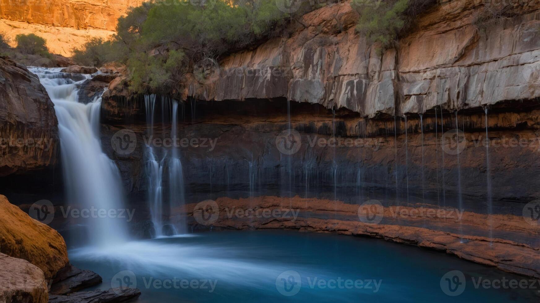 A serene waterfall cascading into a tranquil pool surrounded by rocky cliffs and vegetation. photo