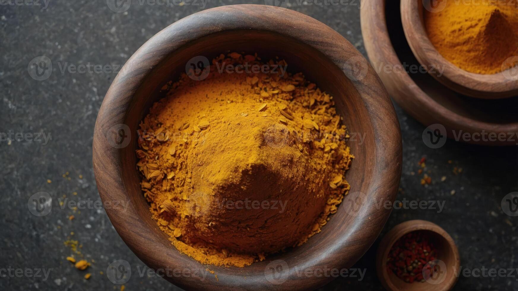 A close-up of turmeric powder in wooden bowls, showcasing its vibrant color and texture. photo