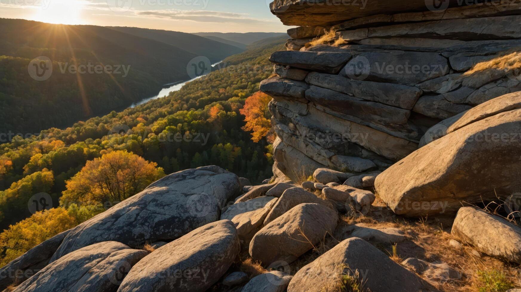 Scenic view of a river valley at sunset, with rocky foreground and autumn foliage. photo