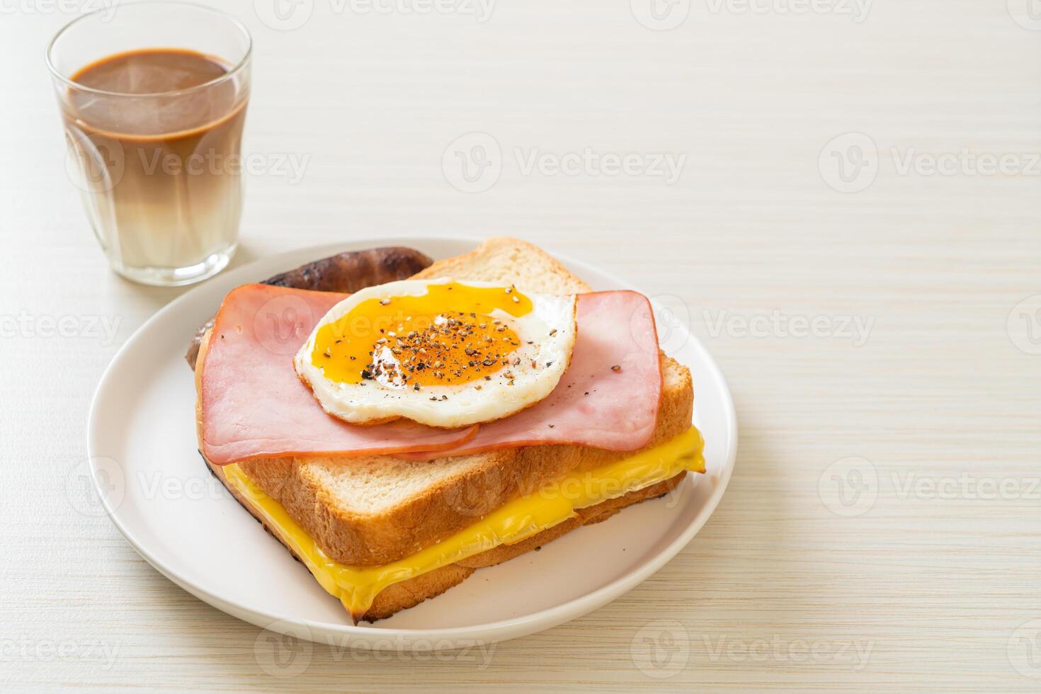 bread toasted cheese topped ham and fried egg with pork sausage. photo