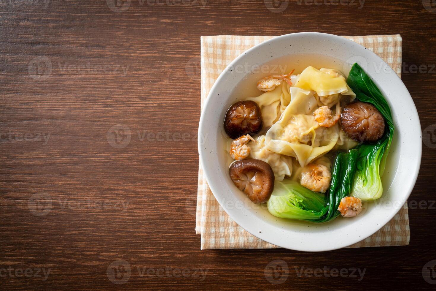 pork dumpling soup with shrimps and vegetable on dark background photo