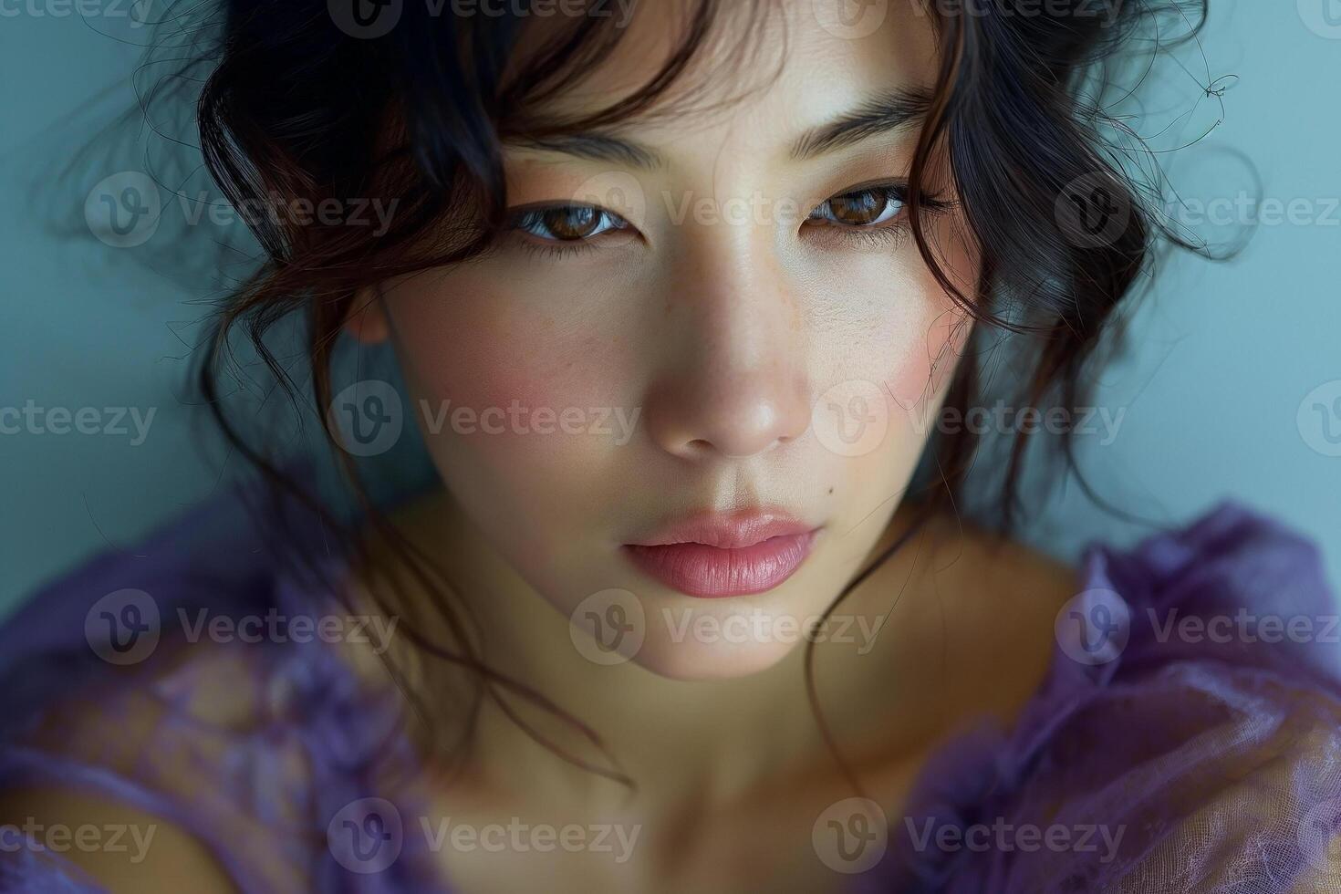 A close-up portrait of a young East Asian woman with soft features, wearing a delicate purple top that highlights her natural beauty. photo