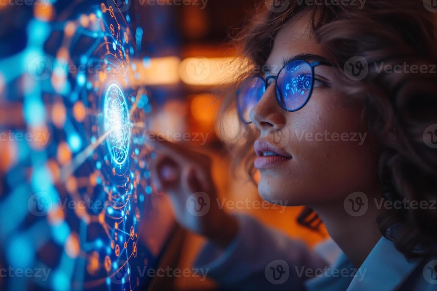 A thoughtful young woman with curly hair and glasses interacts with a glowing digital interface, immersed in technology. photo