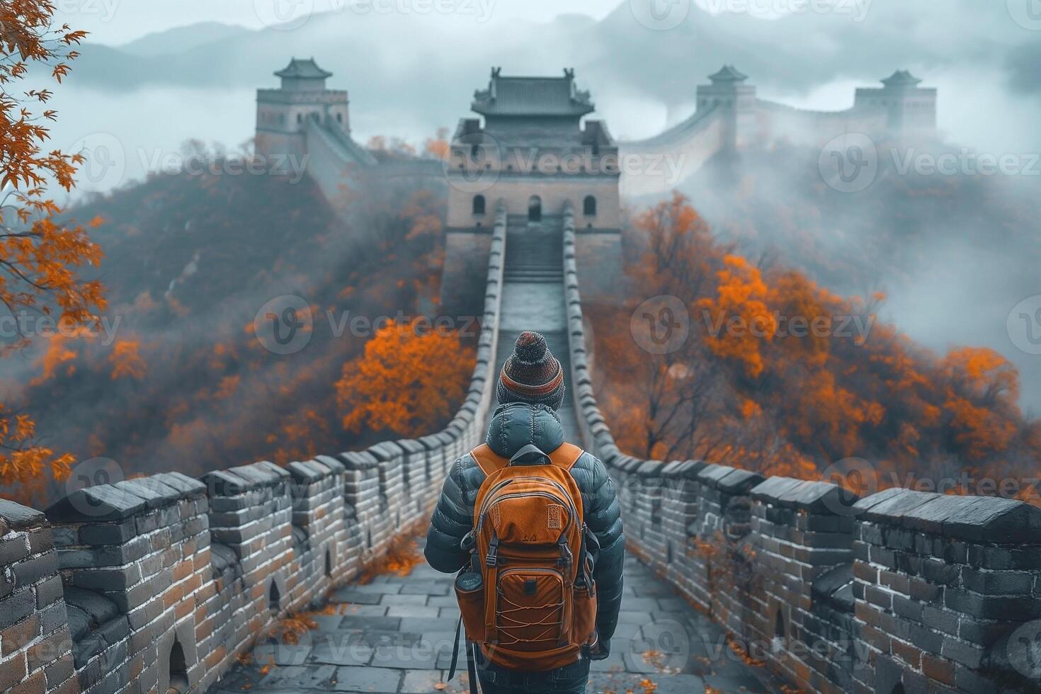 A traveler gazes at the misty Great Wall of China, surrounded by vibrant autumn foliage. photo
