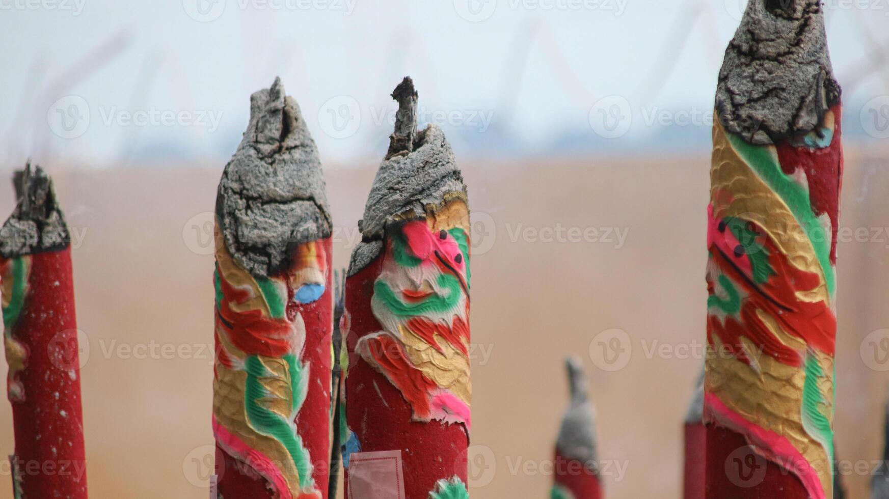 During the Lunar New Year celebrations, large incense sticks in shades of red, purple, and gold stand proudly, their swirling smoke carrying prayers for health, happiness, and success. photo