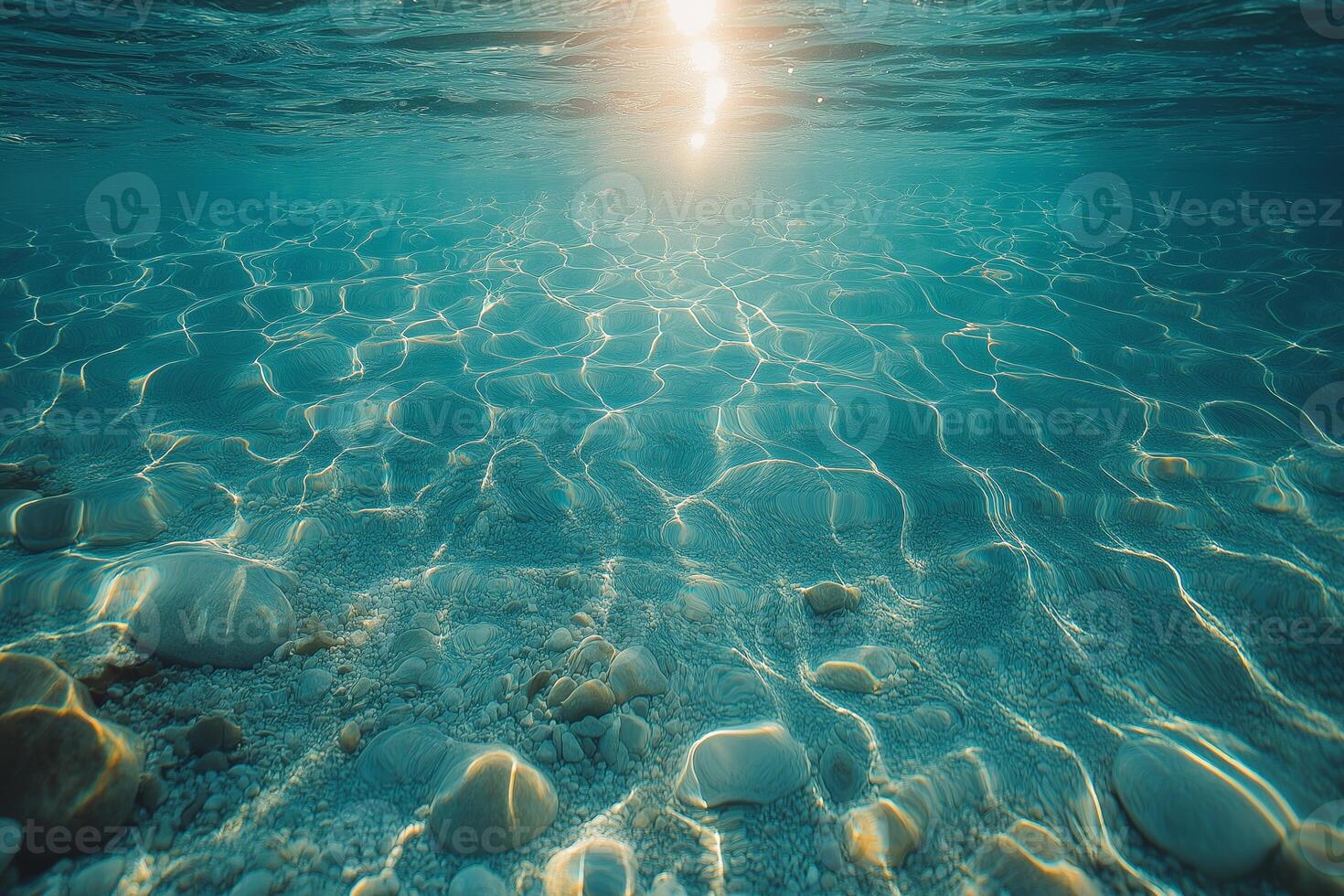 Serene underwater scene showcasing sparkling sunlight filtering through clear water, illuminating smooth pebbles beneath. photo