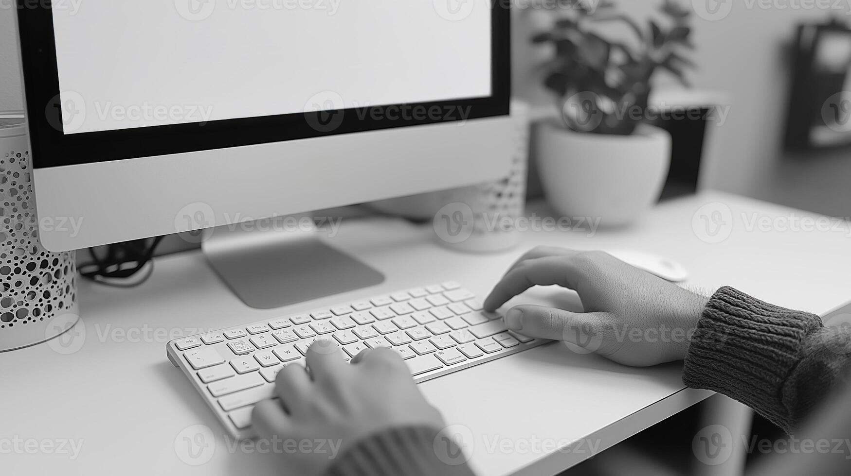 A close-up of a person typing on a sleek keyboard at a minimalist workspace, featuring a potted plant in the background. photo