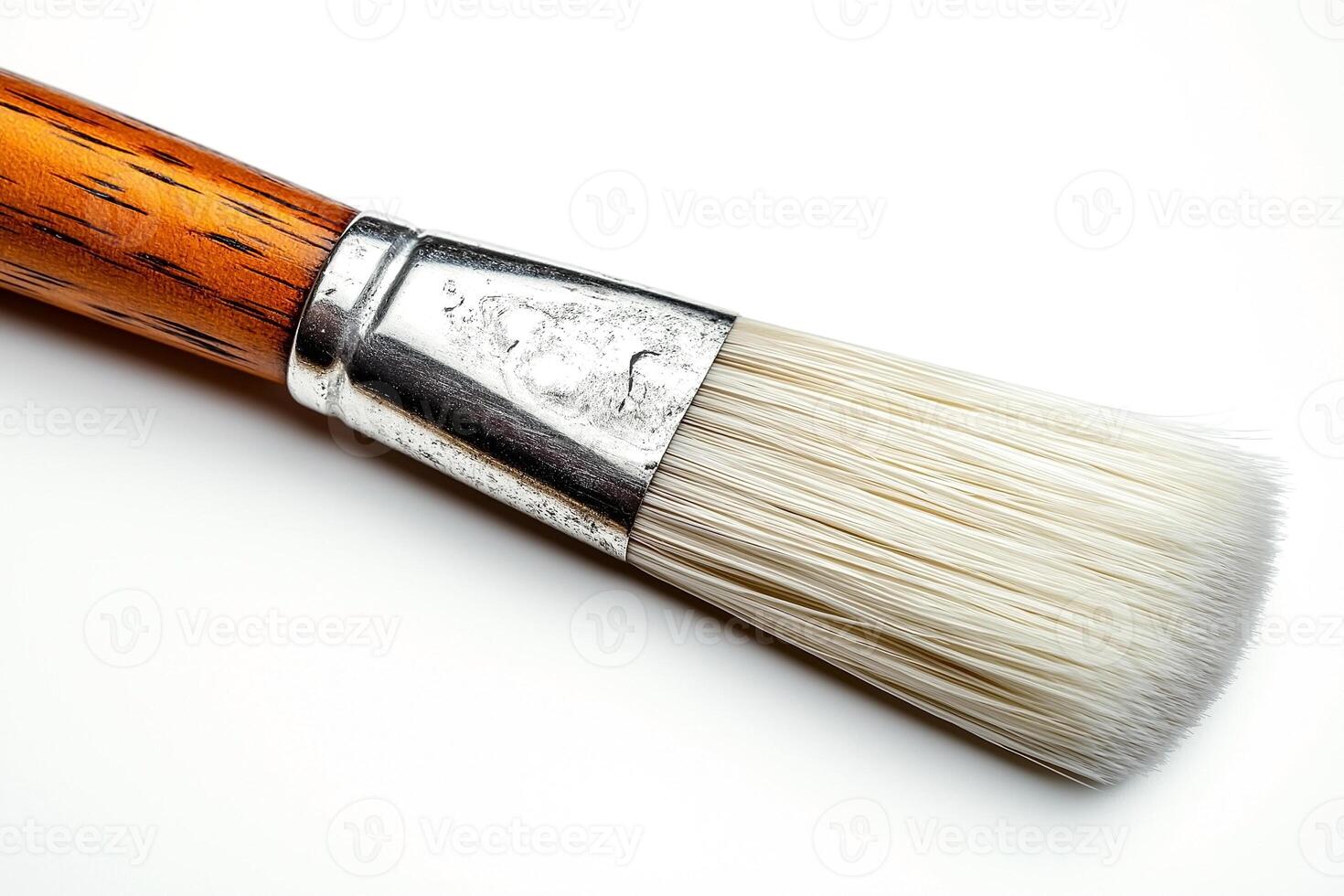 Close-up of a paintbrush with a wooden handle and soft bristles against a white background. photo