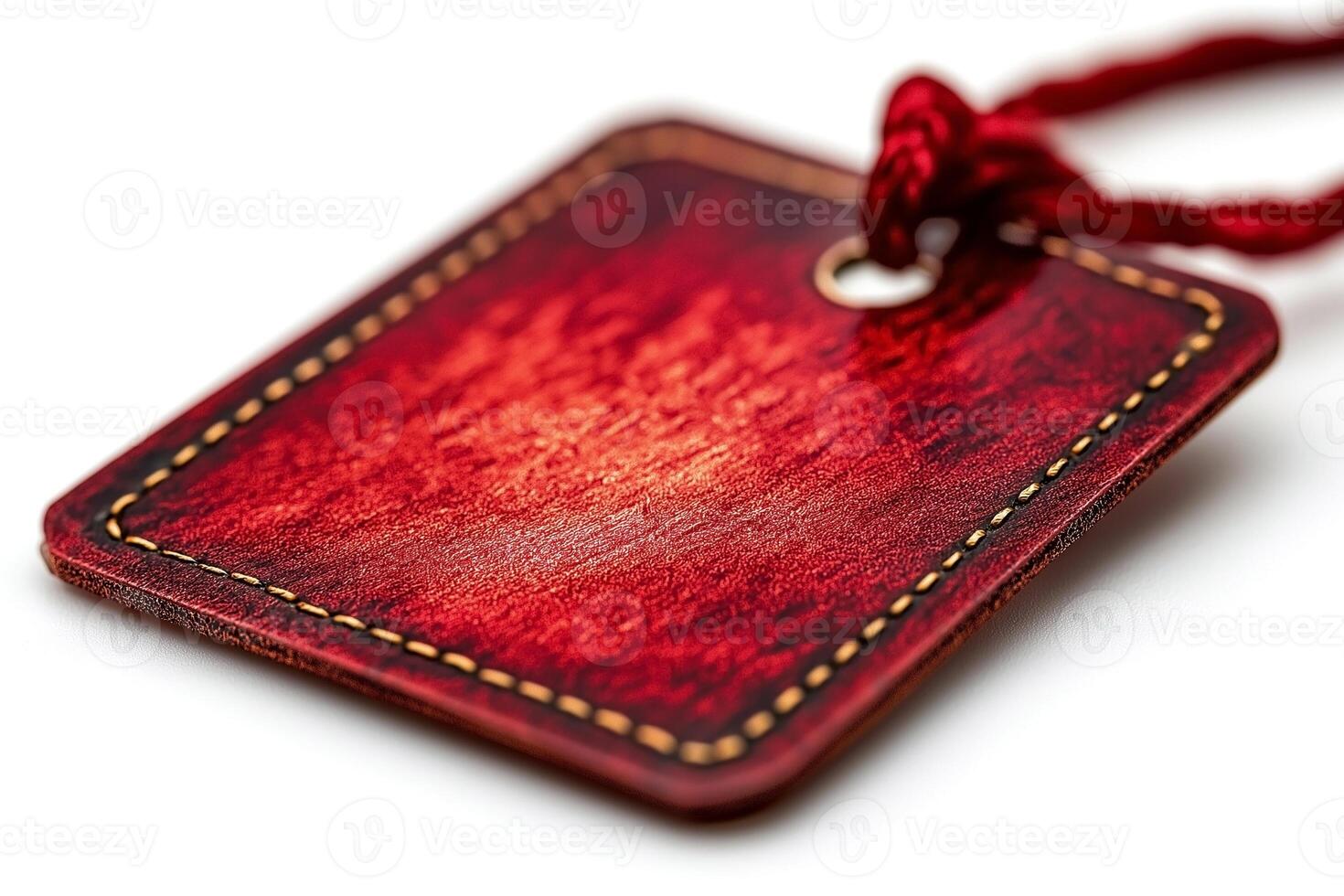 Close-up of a reddish-brown leather tag with decorative stitching and a red string. photo