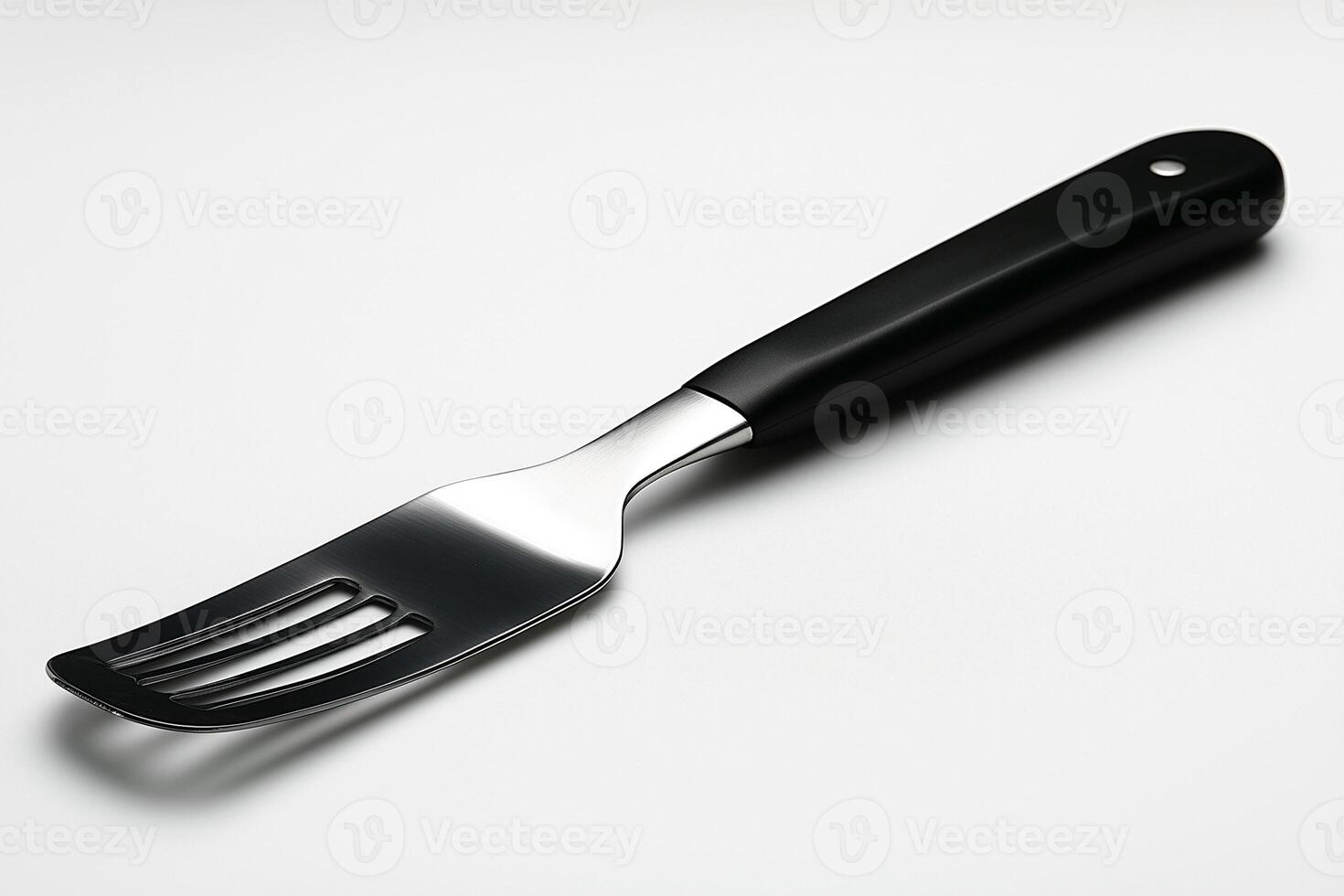 A sleek stainless steel serving fork with a modern black handle, perfect for elegant dining. photo