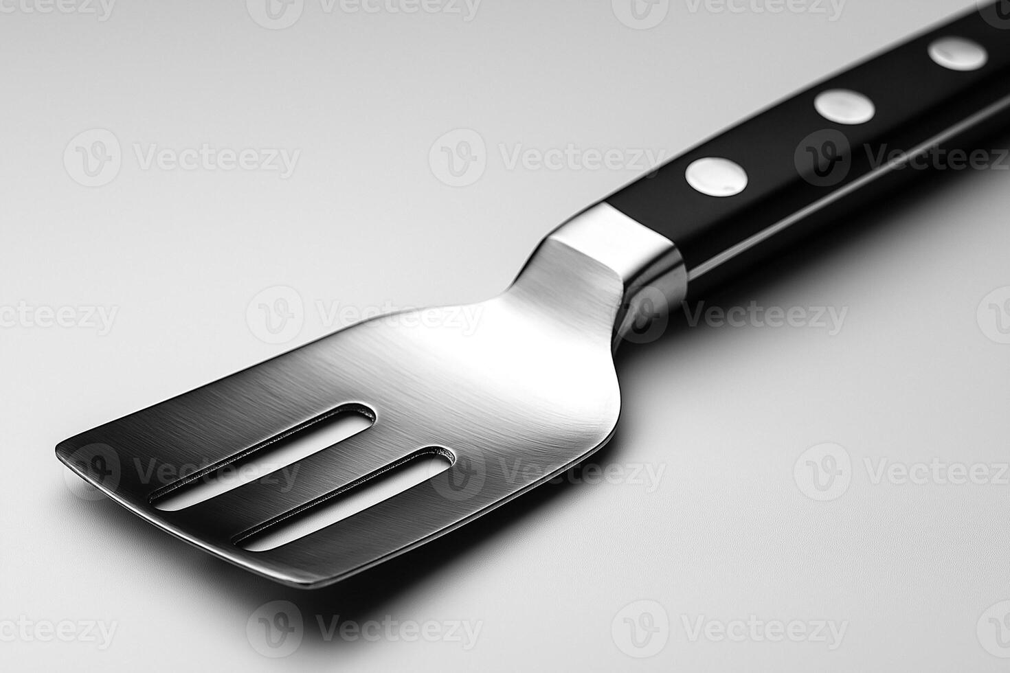 A sleek, modern stainless steel spatula with a black handle, ideal for cooking and grilling. photo