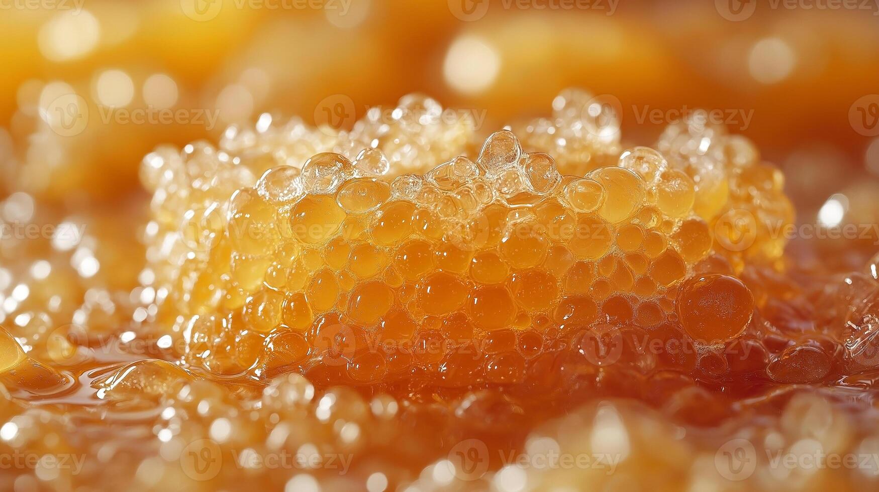 Close-up of golden honeycomb, showcasing its rich texture and bubbly surface against a warm amber background. photo