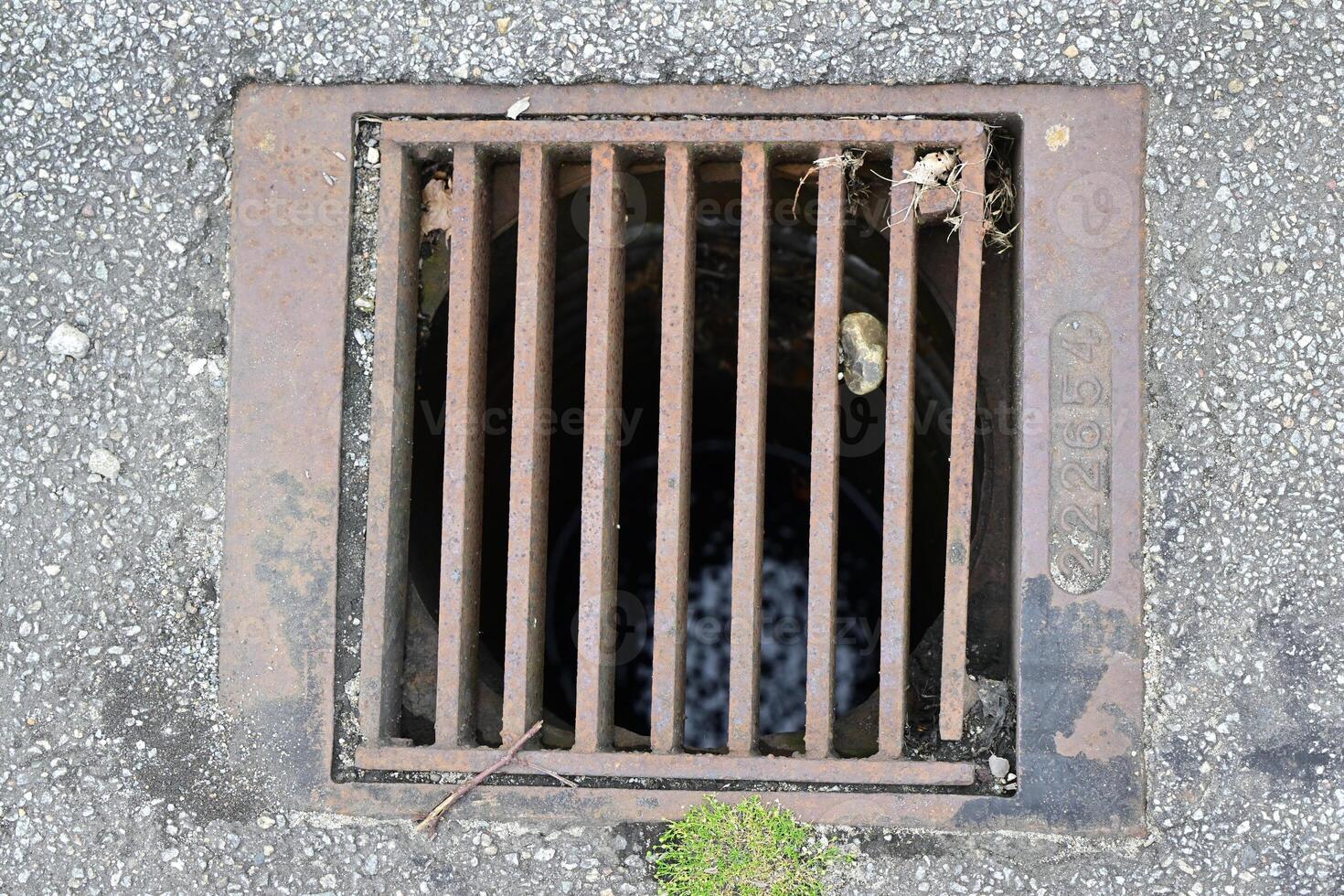 Rusty Storm Drain Cover on Asphalt photo