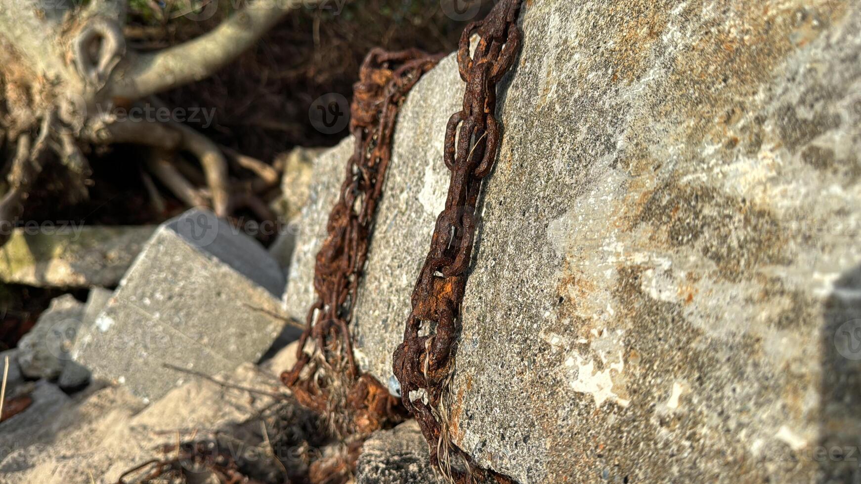 Rusty Chain on Weathered Stone Surface photo