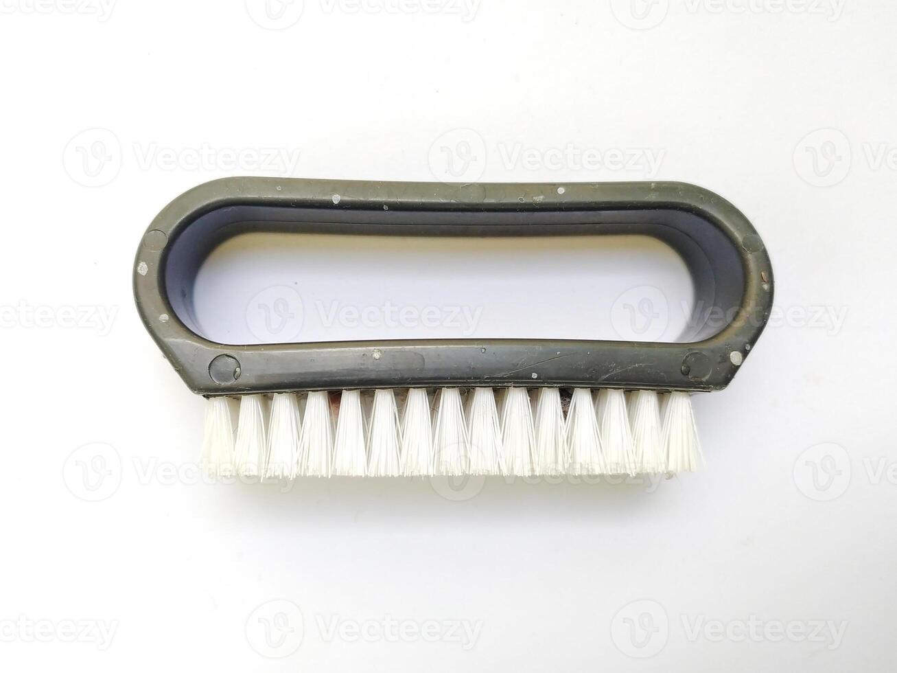 Closeup of a simple, handheld brush with a dark gray plastic handle and white bristles. Perfect for illustrating cleaning, maintenance, or detailing concepts. photo