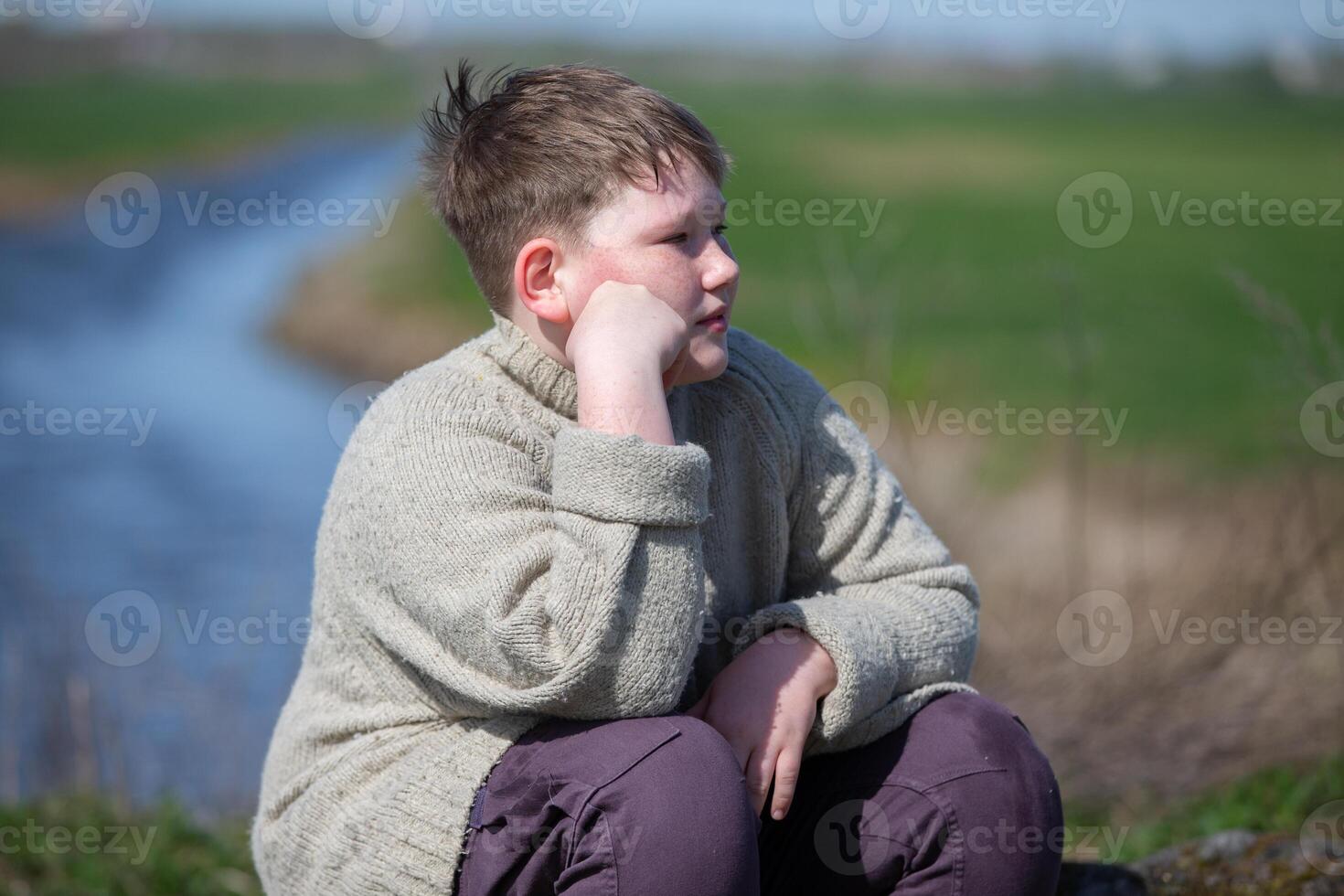A chubby, plump teenage boy of twelve years old sits photo