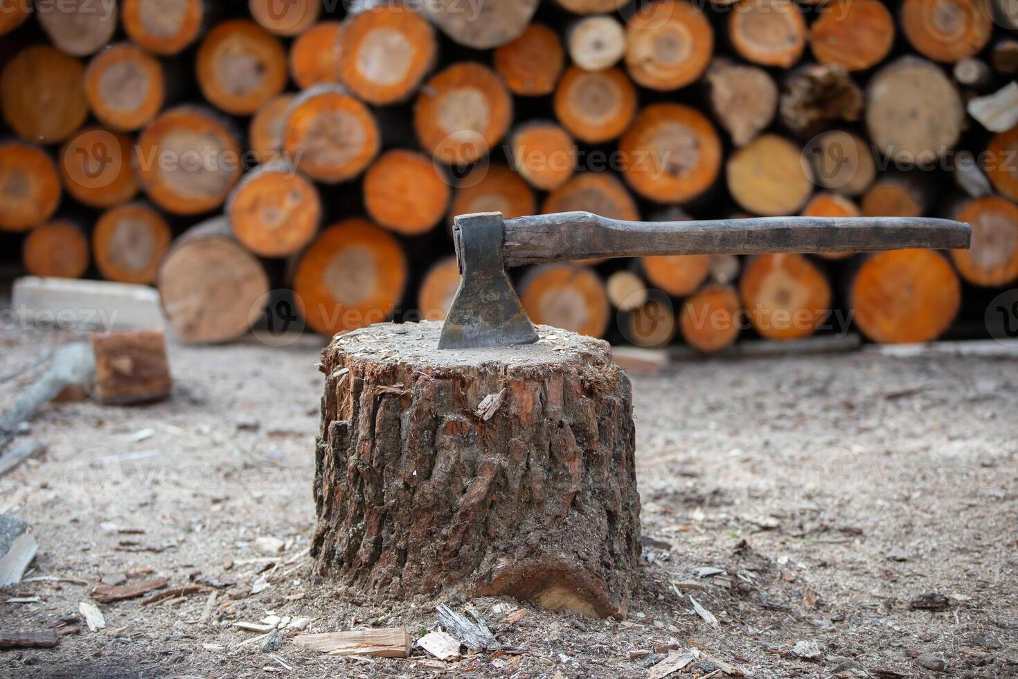 A woodcutter's ax against a background of chopped firewood. photo