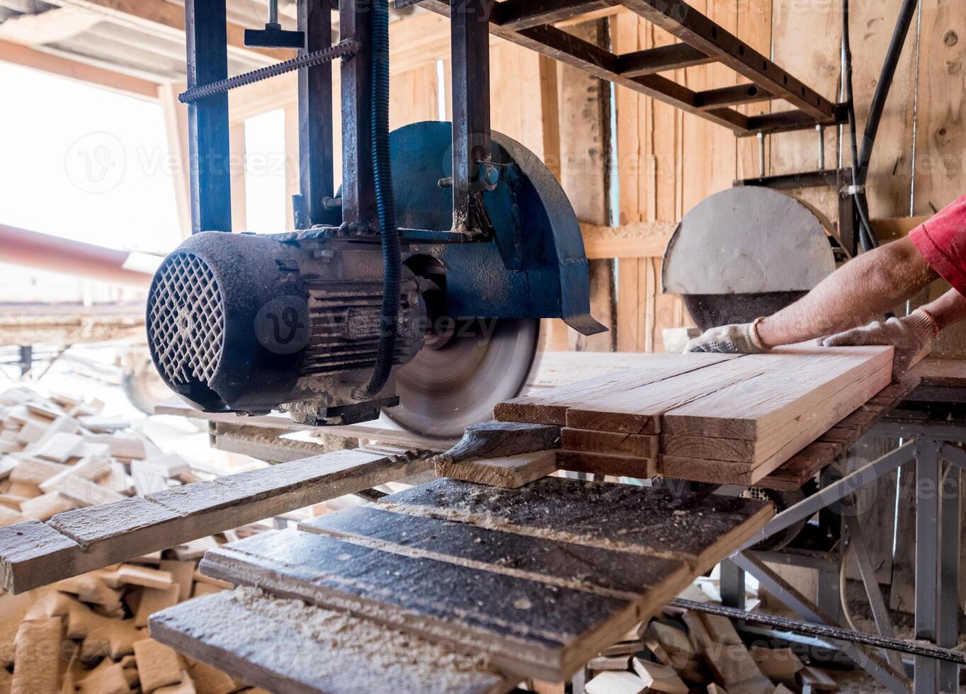 Modern sawmill. A carpenter works on woodworking the machine tool. photo