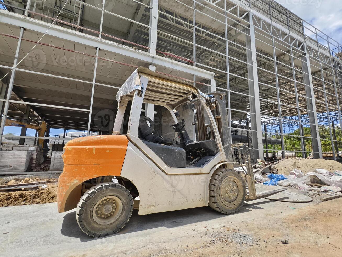 A forklift is parked in front of a building under construction photo