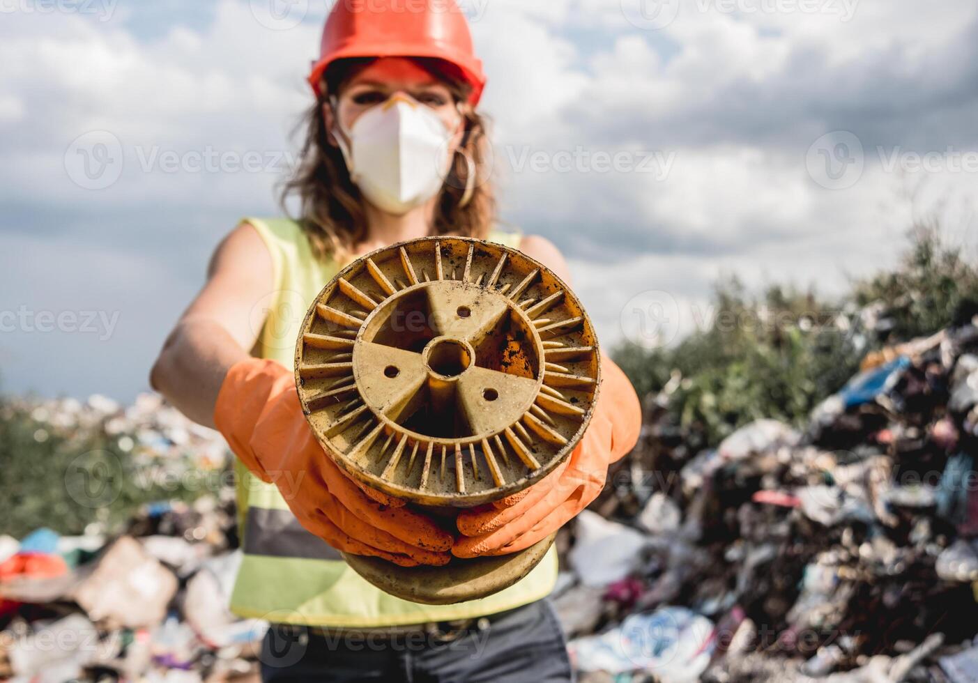 Woman volunteer helps clean the field of nuclear waste and plastic garbage photo
