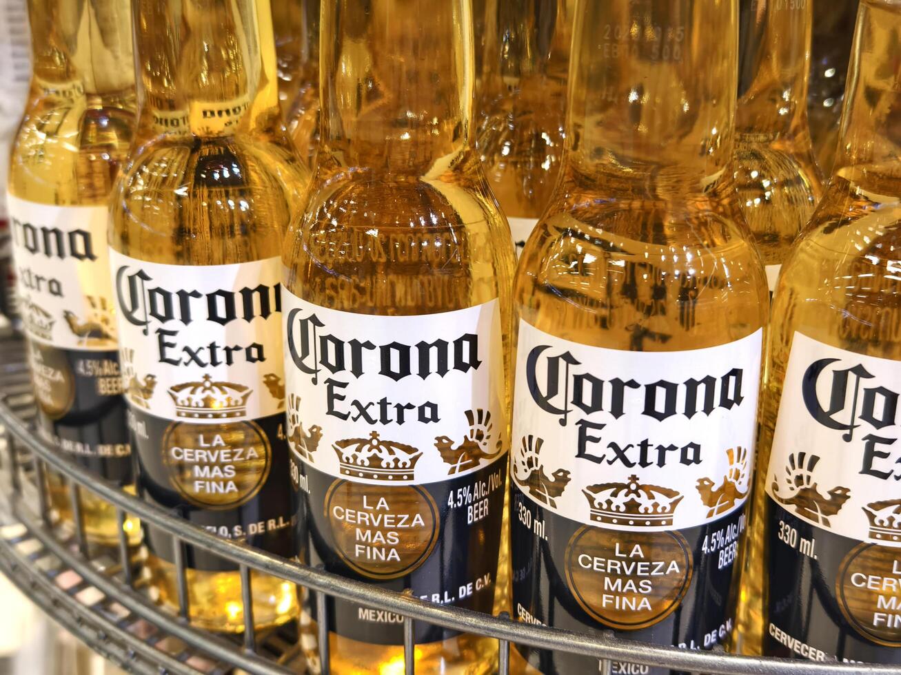 PHUKET, THAILAND - MARCH 8, 2025. Bottles of Corona beer lined up neatly on a shelf photo