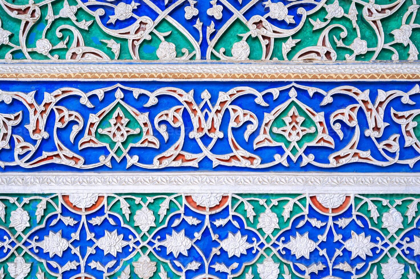 colorful carved wooden painted background with Uzbek ornaments and oriental patterns in Tashkent in Uzbekistan photo