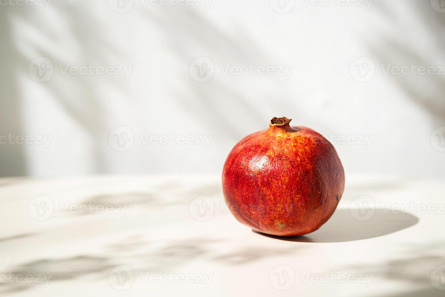 Single Pomegranate in Soft Natural Light with Interesting Shadows. photo