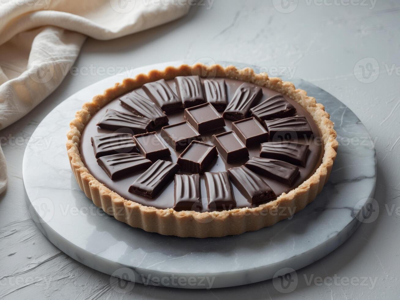 Decadent Chocolate Tart on Marble Surface with Dark Chocolate Squares and Soft Textile Background photo
