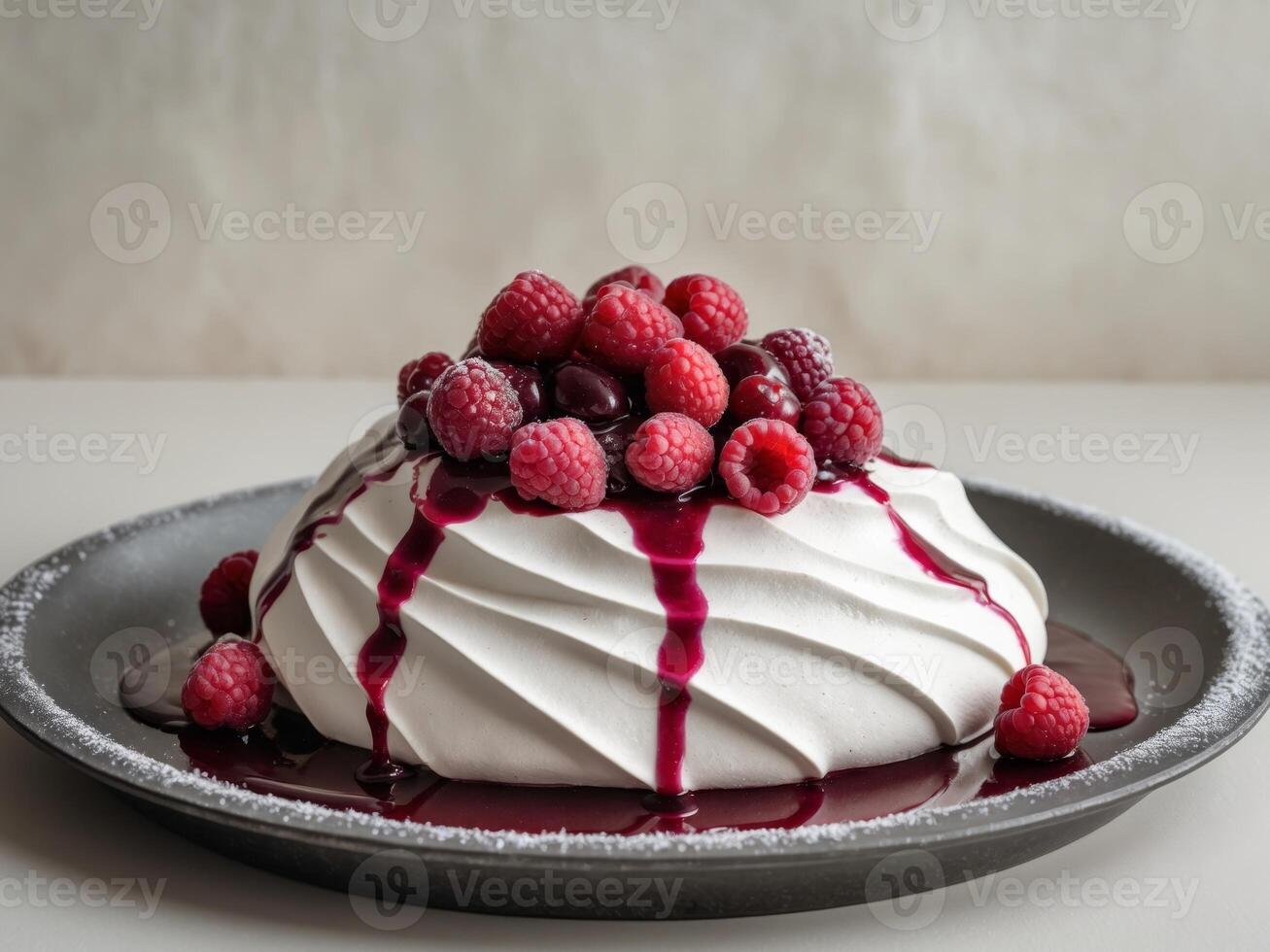 Delicious Pavlova Dessert Topped with Fresh Raspberries and Berry Sauce on a Dark Plate with Sugar Dusting photo