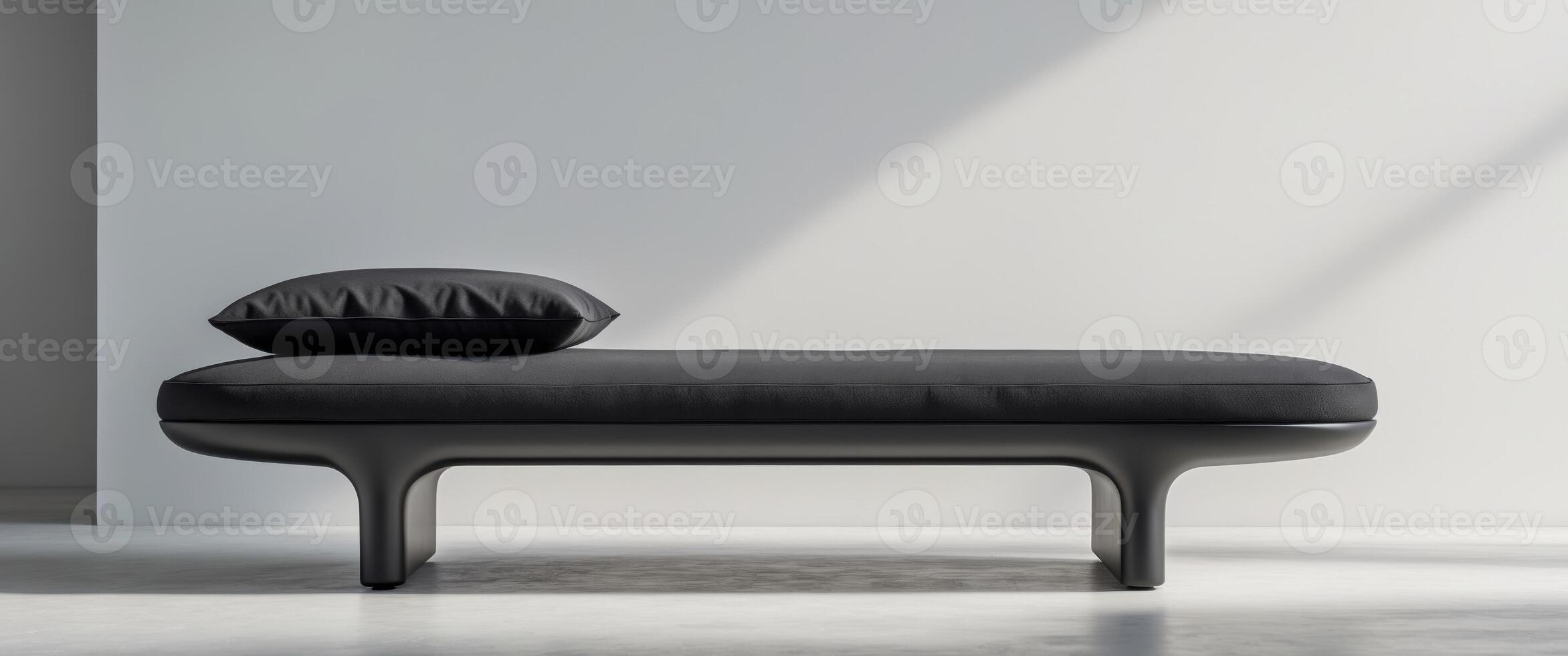 A black ottoman with a cushion on it photo