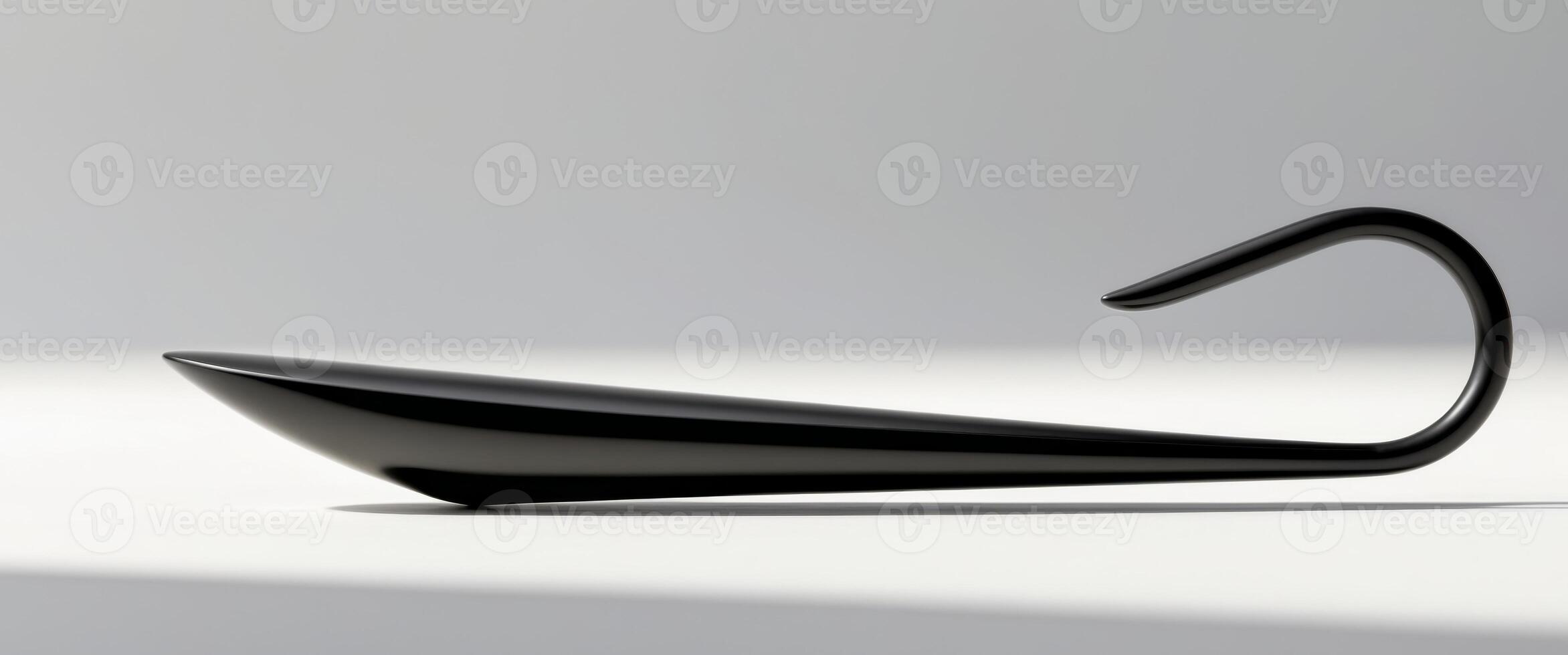 A black object with a handle and a curved end. photo