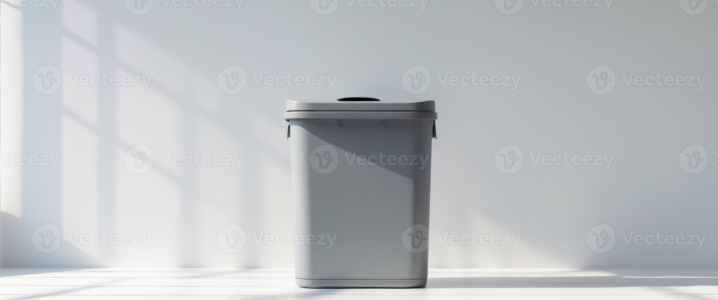 Gray recycle bin with lid displayed on white surface. photo
