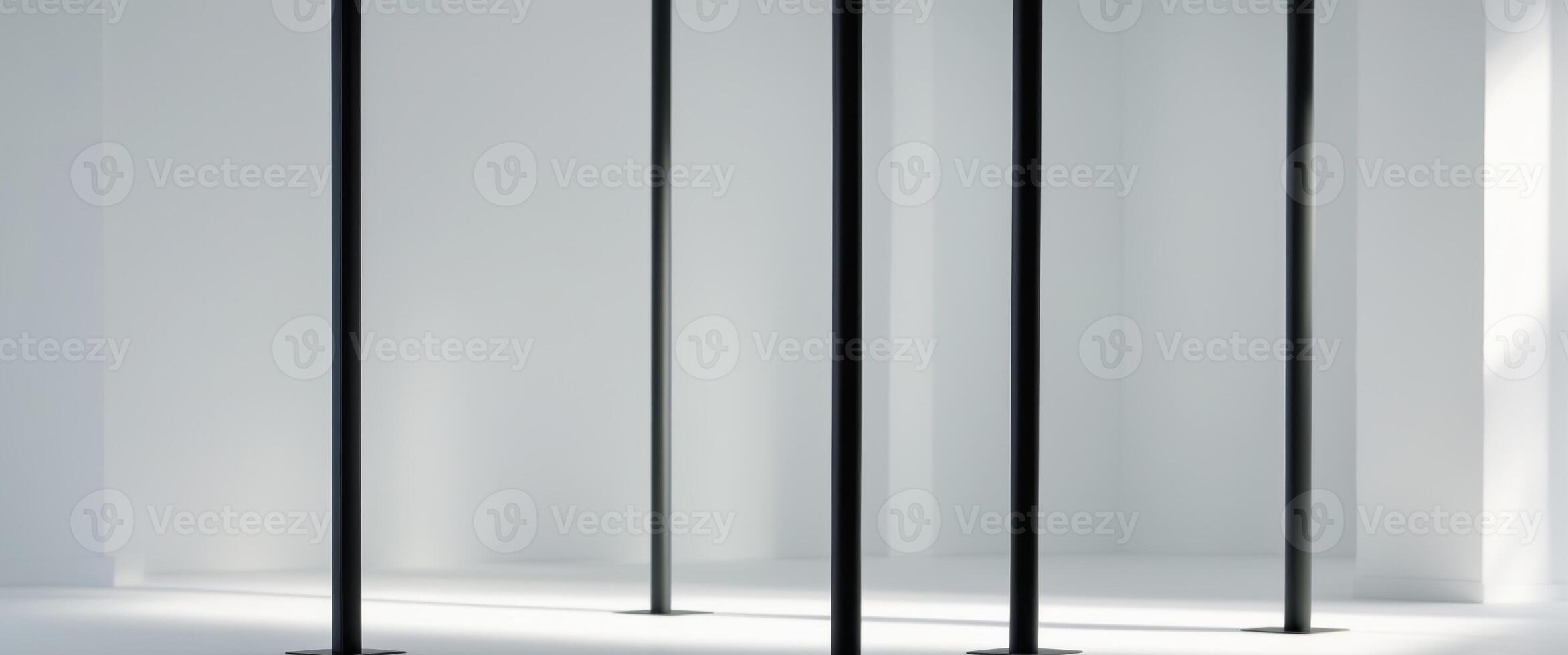 Four black poles are standing upright in a room. photo