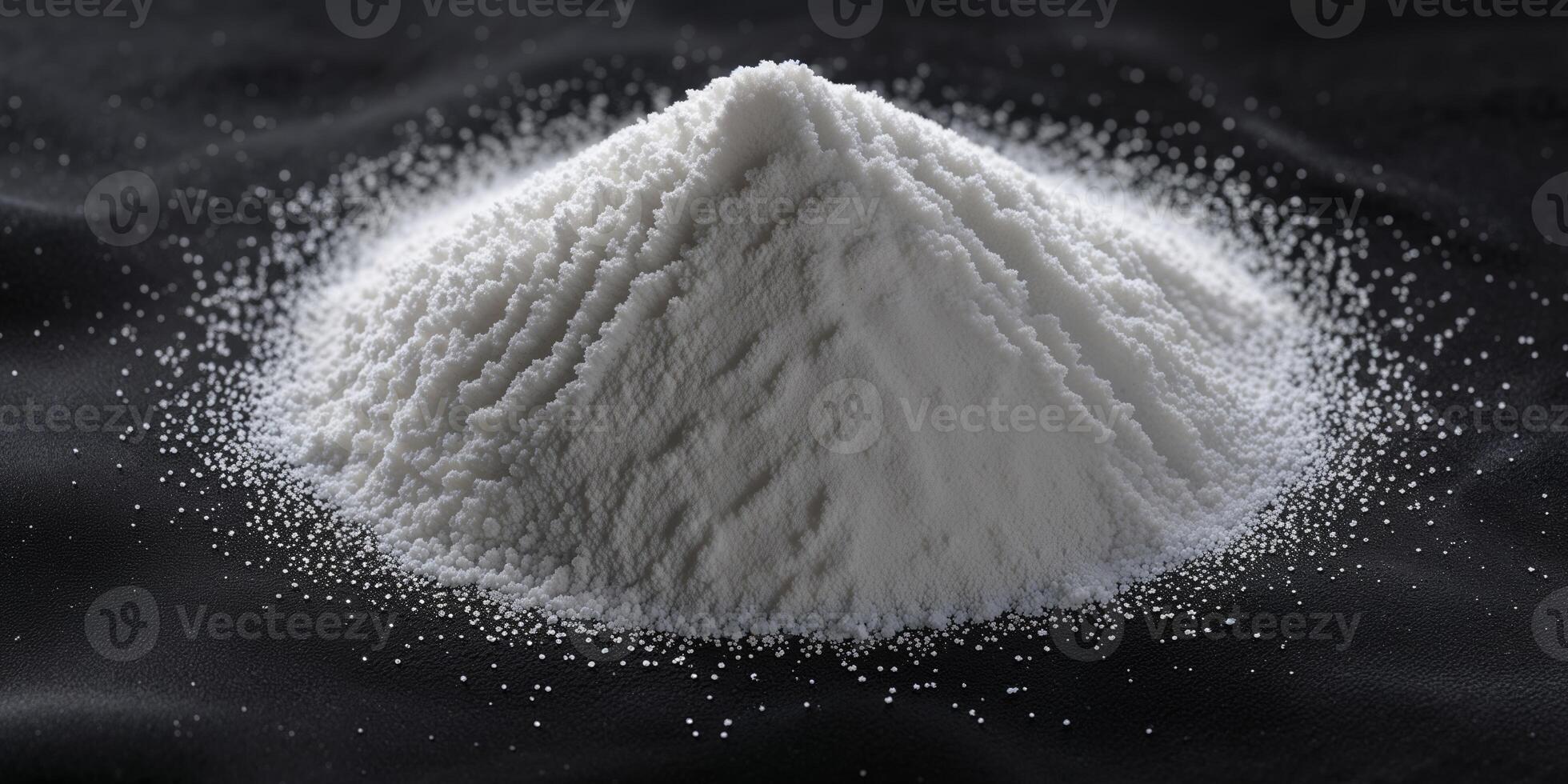 Pile of white sugar on a black background creating a striking contrast in a simple still life composition. photo