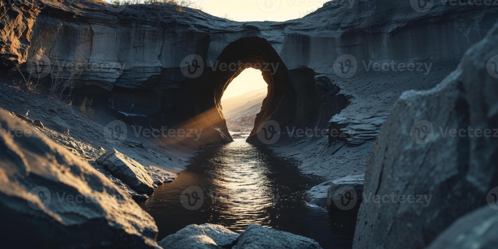 Dramatic rock formation with dark tunnel and water. photo