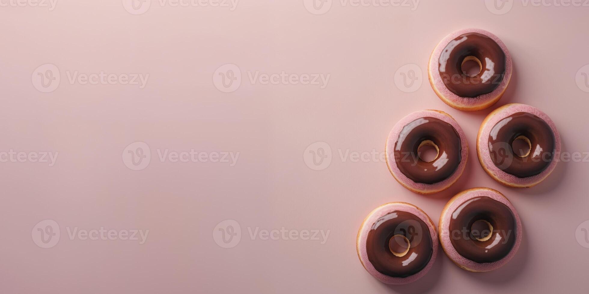 Donuts with chocolate on light pink background. photo