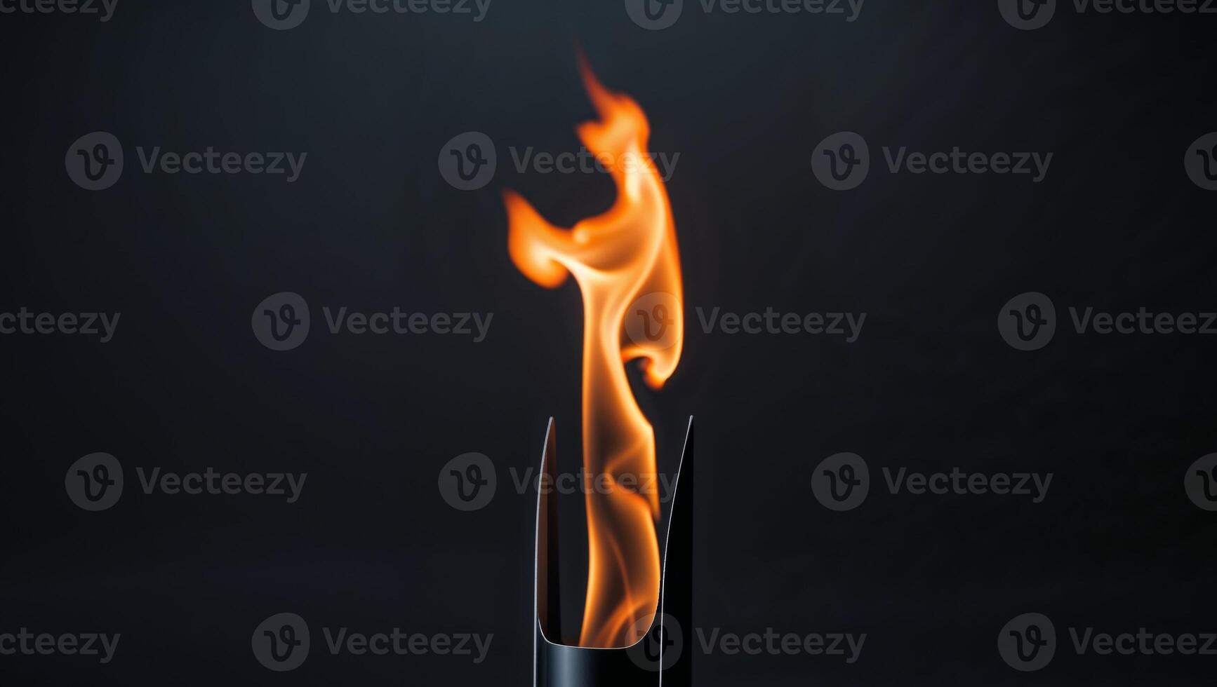 Flaming torch with orange flames on black background photo