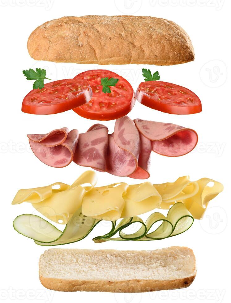 Floating sandwich ingredients bread, tomato slices, parsley, ham, cheese, and cucumber arranged in layers, isolated on a white background. photo