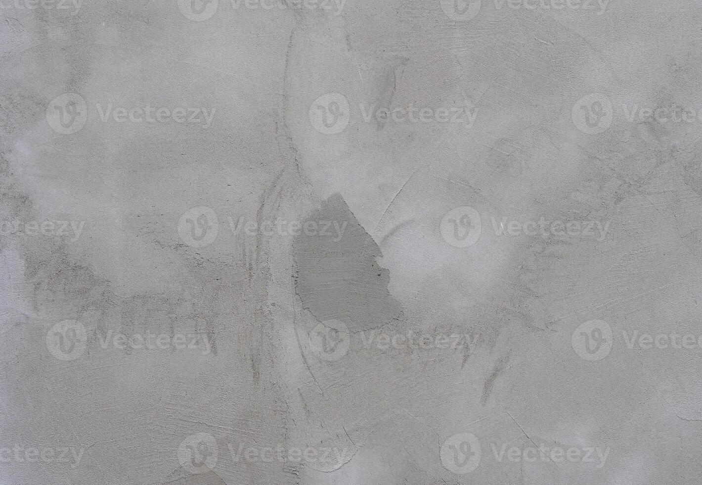 Close-up of a gray concrete wall with rough texture and irregular patterns. The surface has a natural, industrial photo