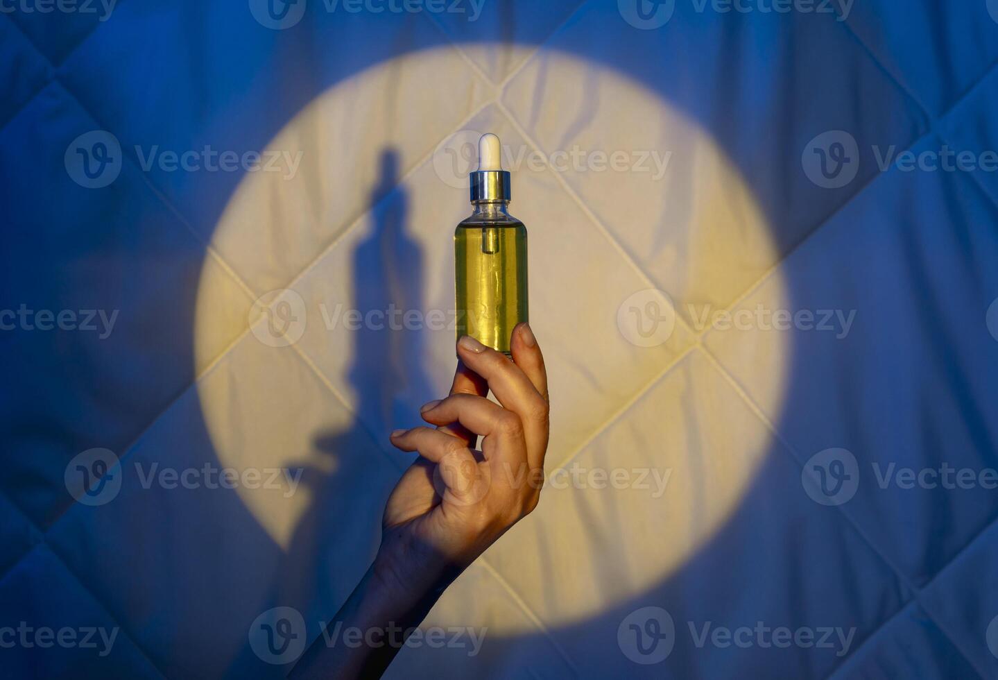 woman hand on the background of a quilt in the light of the moon with dropper with sleeping oil. Fighting insomnia photo
