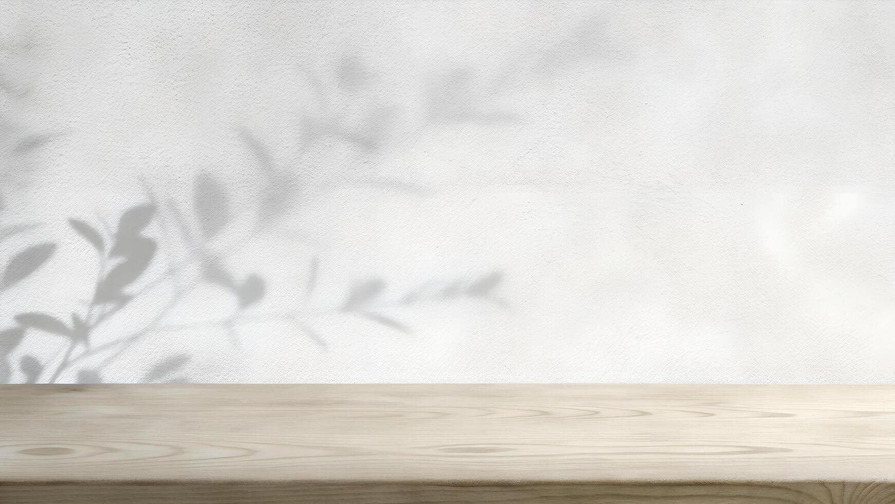Empty wooden table with shadow of leaves on white wall photo