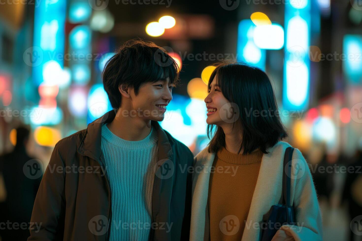 A young couple standing in the middle of a city street at night photo