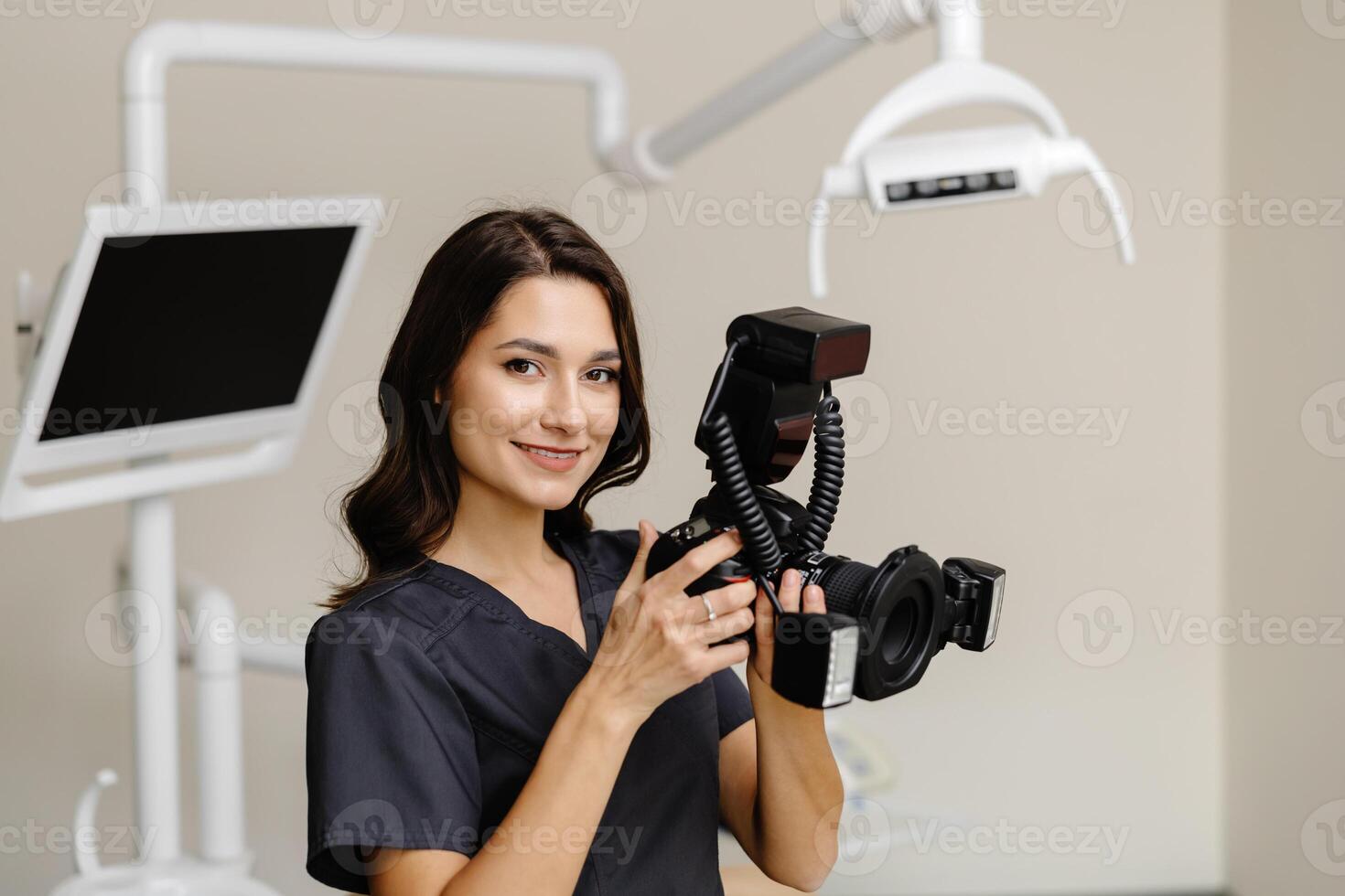 Woman dentist holding camera in hands and taking photos of patient teeth at clinic